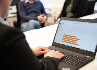 Mann am Laptop von Hinten